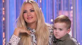 Carrie Underwood holding a child on her lap on American Idol