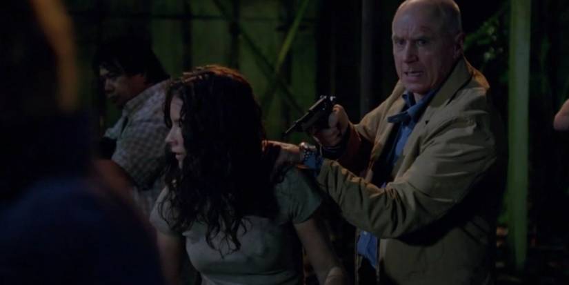 Charles Widmore (Alan Dale) pointing a gun at a girl in Lost.