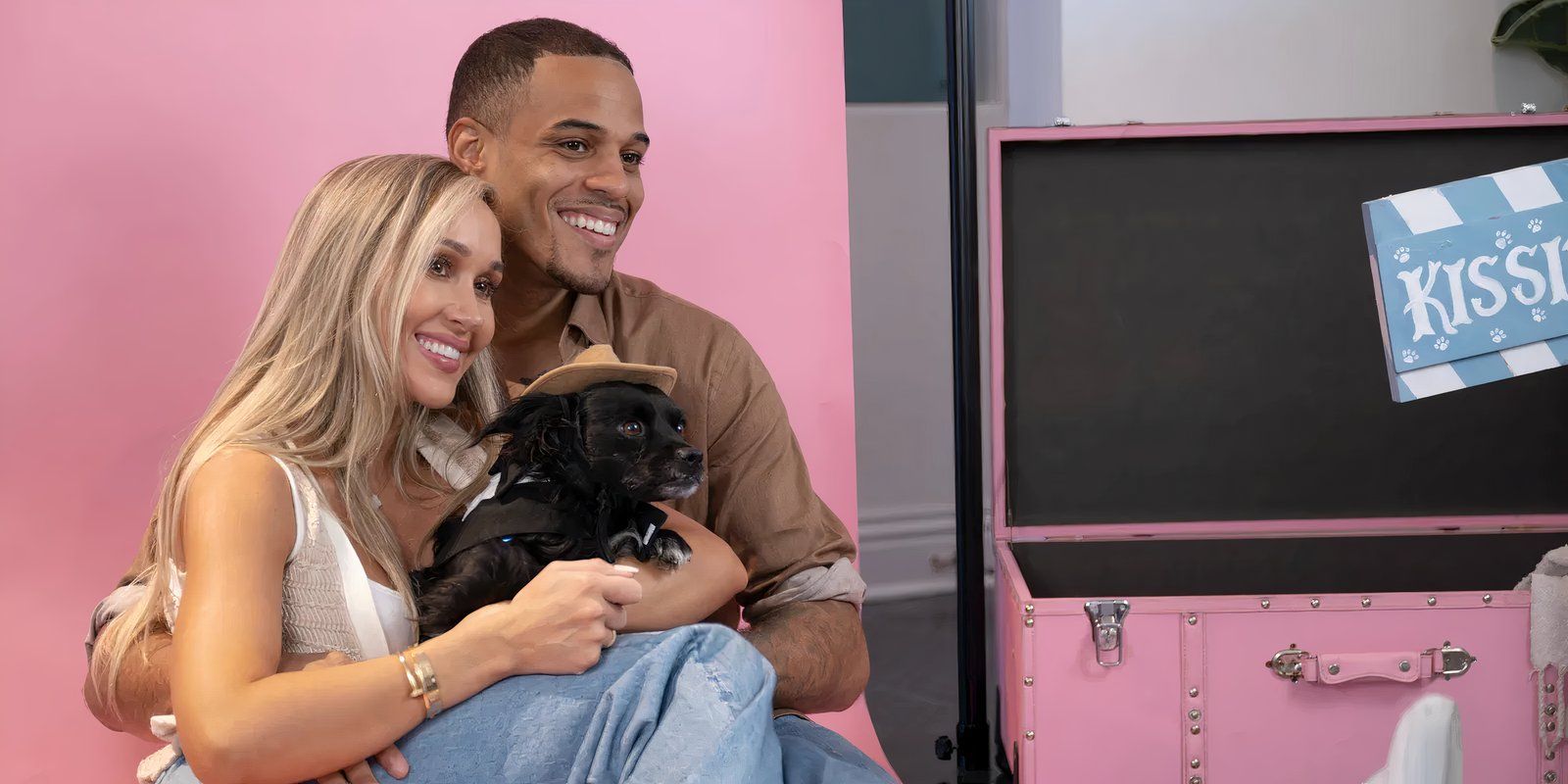 Dina Lupancu and Grant Ellis sit and take pictures with a dog on The Bachelor 29