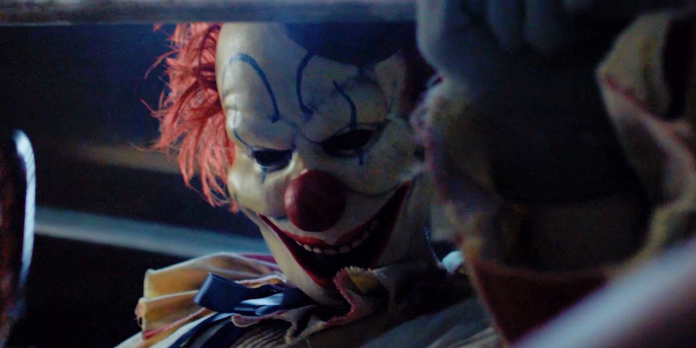 Frendo the Clown holding a knife while standing over a weight bench in Clown in a Cornfield