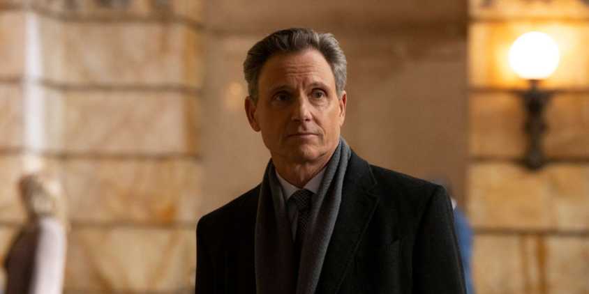Law & Order Baxter standing by the courthouse wearing a scarf, coat, and tie