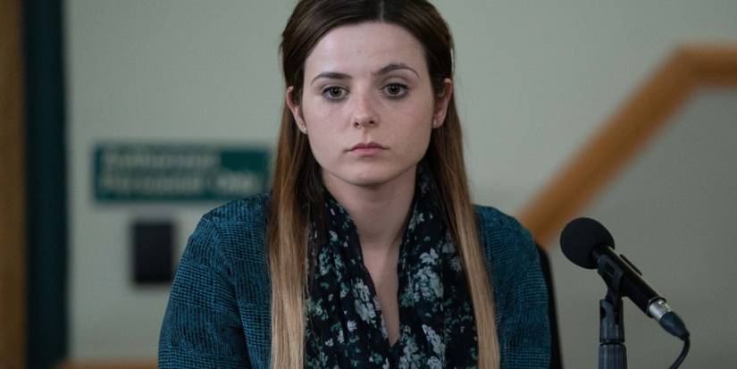 Maggie from three women looking upset in front of a microphone