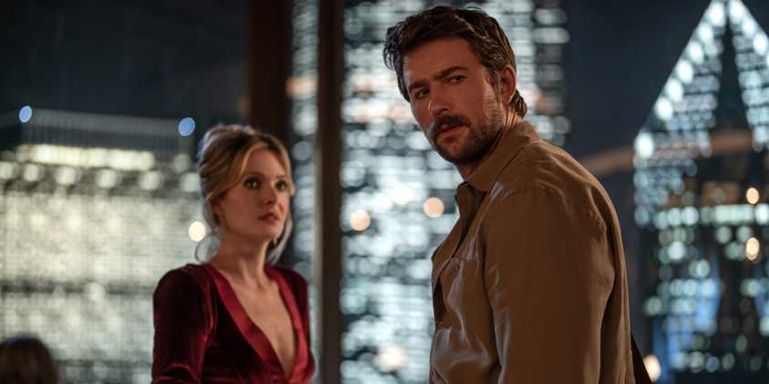 Meghann Fahy and Brandon Sklenar look at something in Drop