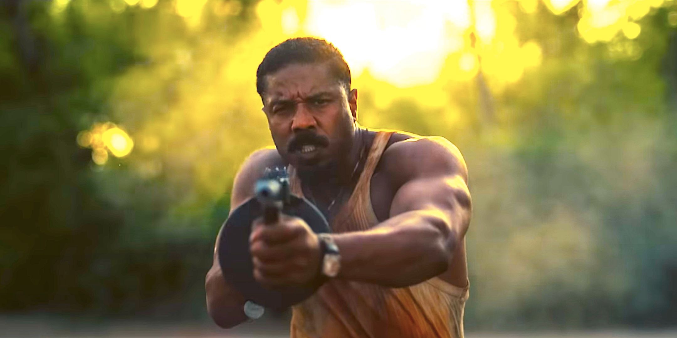 Michael B Jordan's Elijah aims a tommy gun at the camera in Sinners 2025