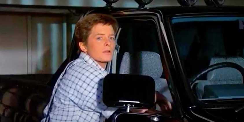 Michael J Fox's Marty stares while standing at his jeep in Back to the Future's ending