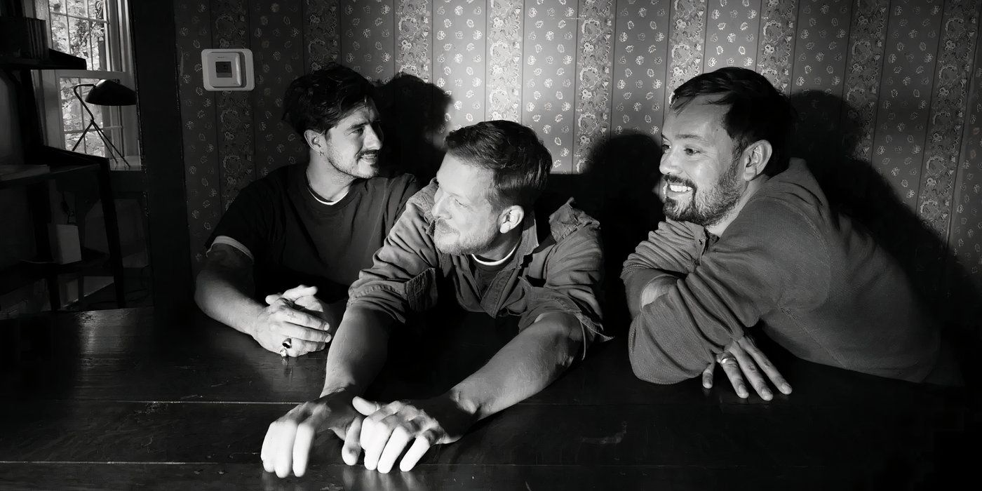 Mumford &amp; Sons are pictured sitting together at a table in black &amp; white.