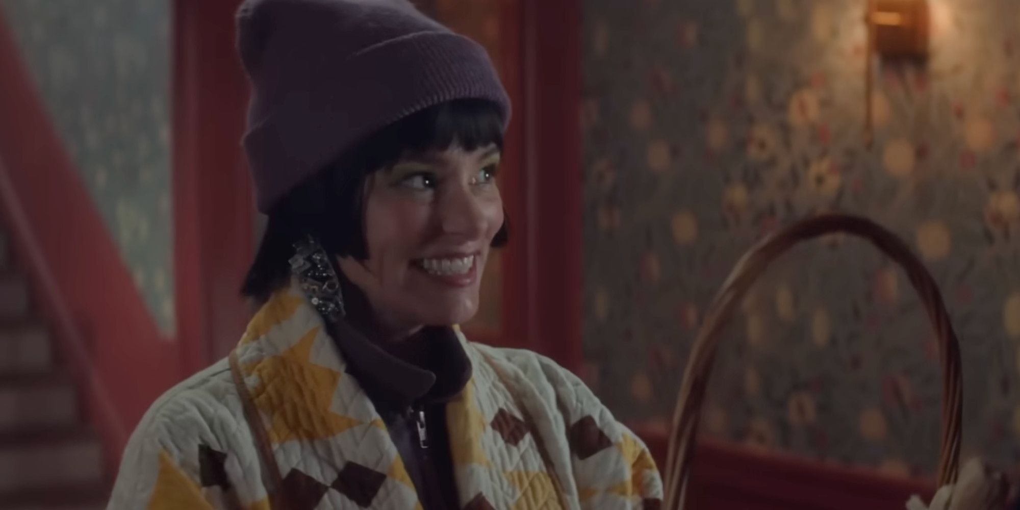 Parker Posey in The Parenting smiling awkwardly while holding a basket 