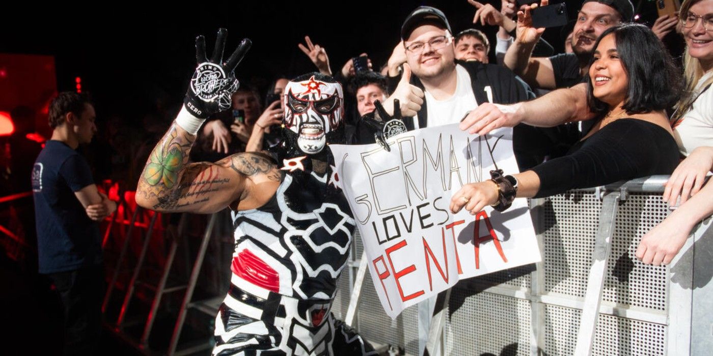 Penta holds up a sign at a WWE house show in Germany