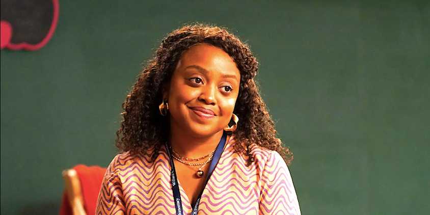 Quinta Brunson's Janine smiles at a desk in Abbott Elementary