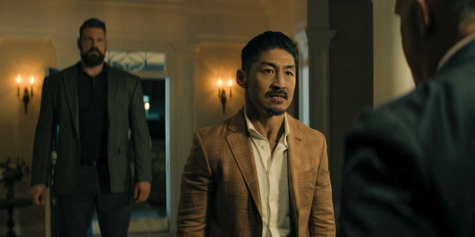 Quinn (Brian Tee) confronting Zachary Beck, with Paulie (Olivier Richters) escorting him in Reacher Season 3 Ep 6