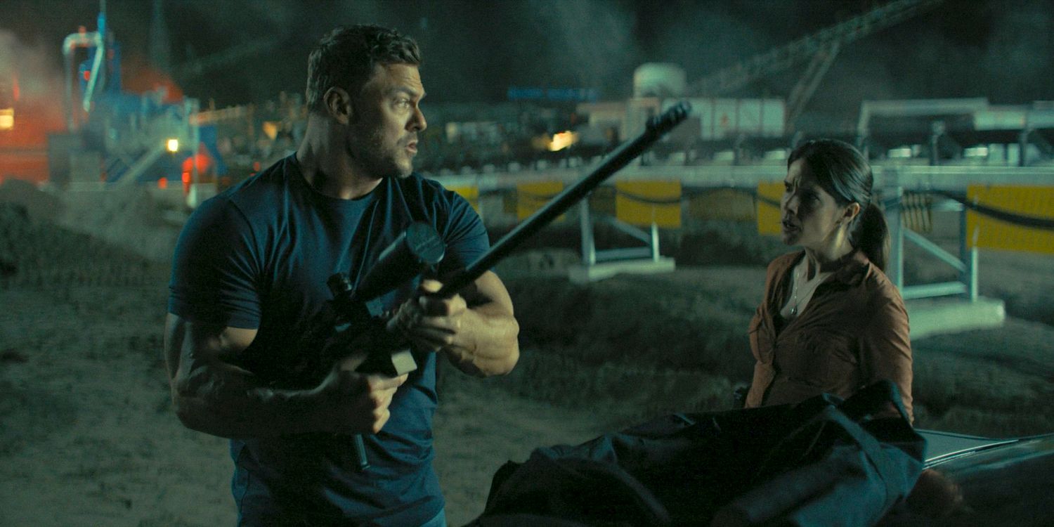Jack Reacher (Alan Ritchson) assembling his rifle as Duffy (Sonya Cassidy) looks at him, upset in Reacher Season 3 Ep 7