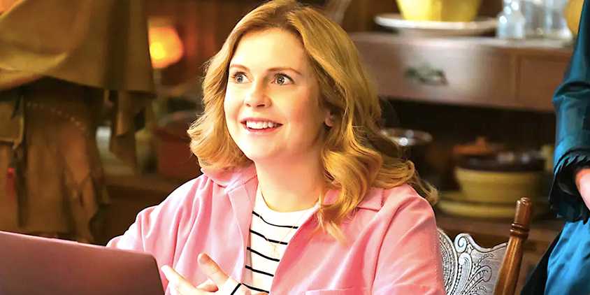Rose McIver's Sam beams at a laptop from Ghosts season 3
