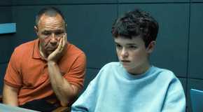 Sephen Graham and Owen Cooper behind a table in Adolescence