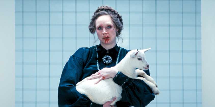 Lorne (Gwendoline Christie) with a bleeding mouth, holding a baby goat in her arms in Severance Season 2 Ep 10