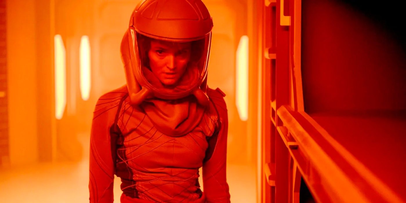 Sharon Garnet (Christie Burke) wearing a space suit while bathed in an orange light in The Ark