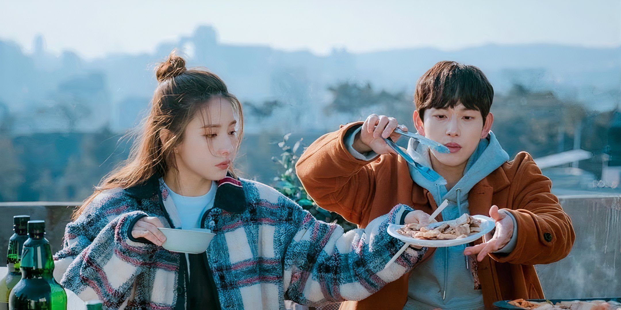 Shin Sae-Kyeong holds out Yim Si-wan's plate as he puts food on it. 