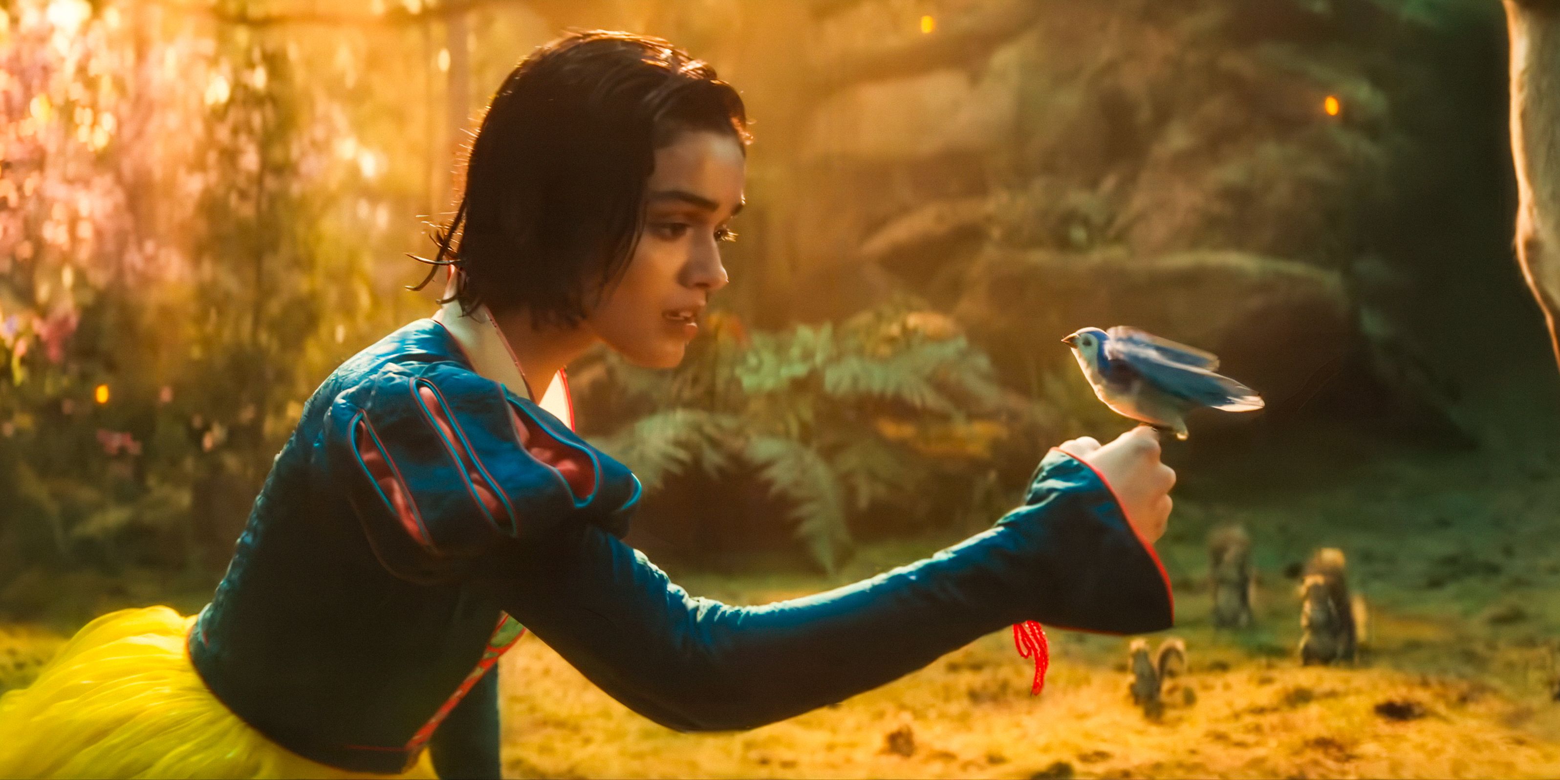 Snow White (Rachel Zegler) looking wondrously at a bird on her hand in Snow White (2025)