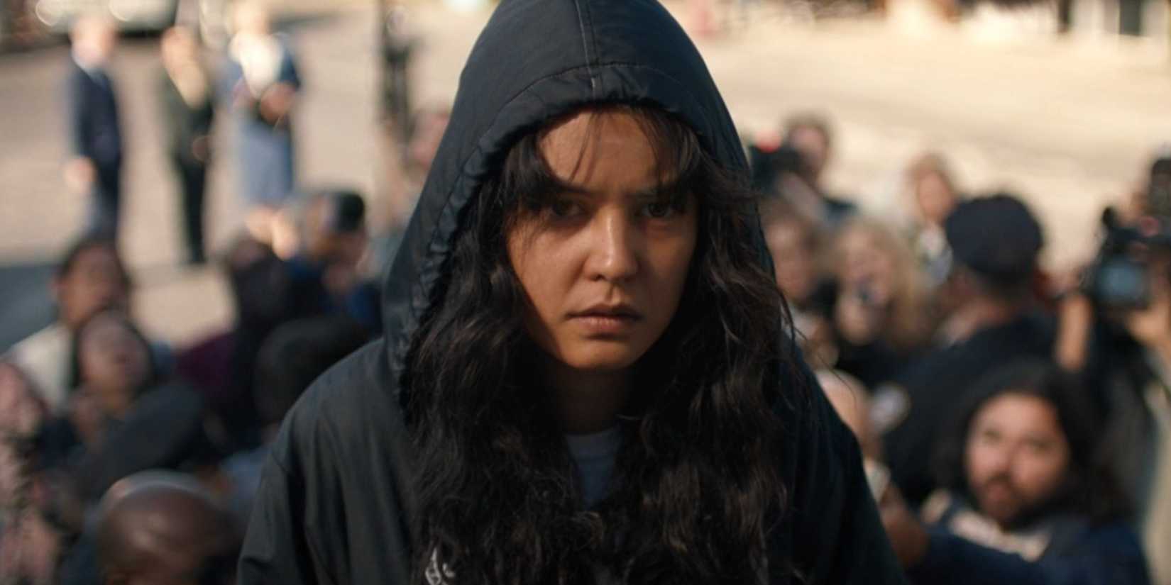 Teen Lottie wearing a hood getting onto a plane after being rescued in Yellowjackets season 2 episode 1