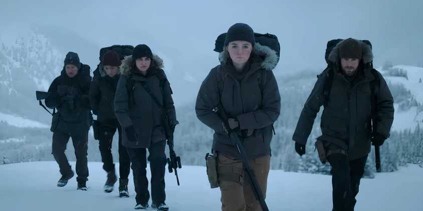 A group of people armed with guns walking through the snow in The Last of Us