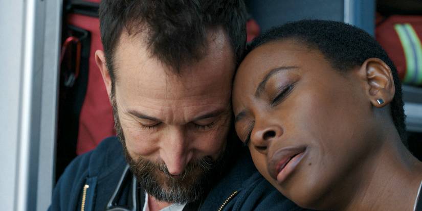 Dr. Heather Collins (Tracy Ifeachor) resting her head on Dr. Robi's (Noah Wyle) shoulder in The Pitt Season 1 Ep 11
