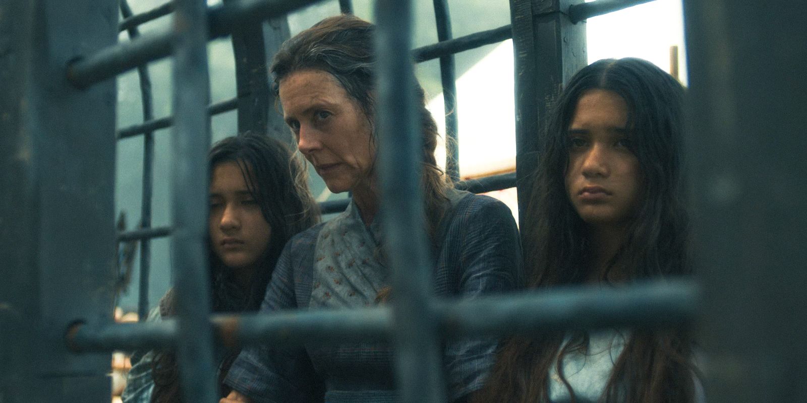 Natti Cauthon (Juliet Howland), Bode Cauthon (Litiana Biutanaseva), and Eldrin Cauthon (Lilibet Biutanaseva) locked in a cell in The Wheel of Time Season 3 Ep 3