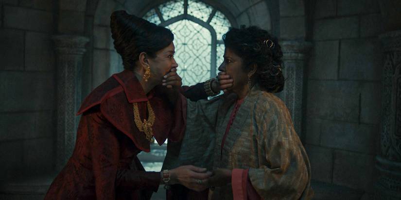 Elaida do Avriny a'Roihan (Shohreh Aghdashloo) and Adeleas Mathwin (Nila Aalia) covering each other's mouths in The Wheel of Time Season 3 Ep 5