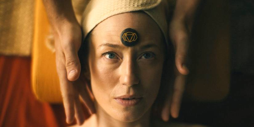 Laurie (Carrie Coon) with a stone on her forehead receiving a massage in The White Lotus Season 3 Ep 3