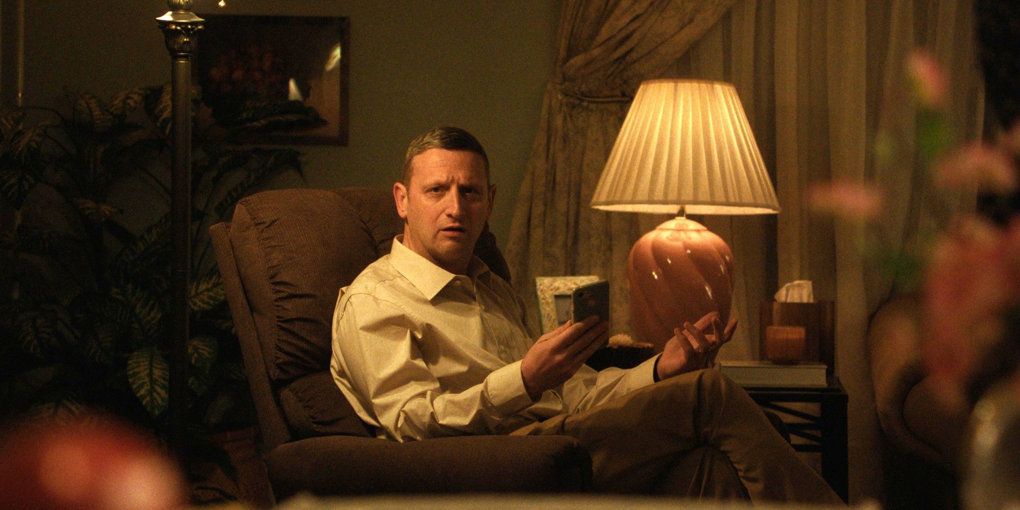 Tim Robinson sits in a recliner and shrugs in Friendship