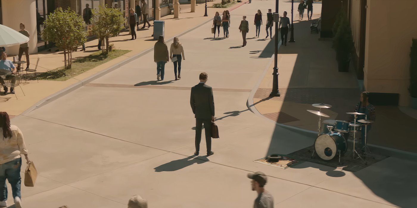 Tom Hiddleston standing on a sidewalk in The Life of Chuck