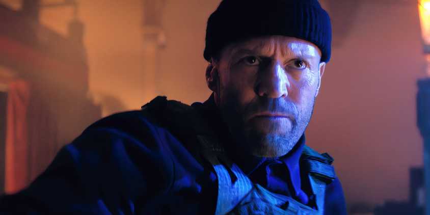 Jason Statham wearing a beanie and scowling in A Working Man