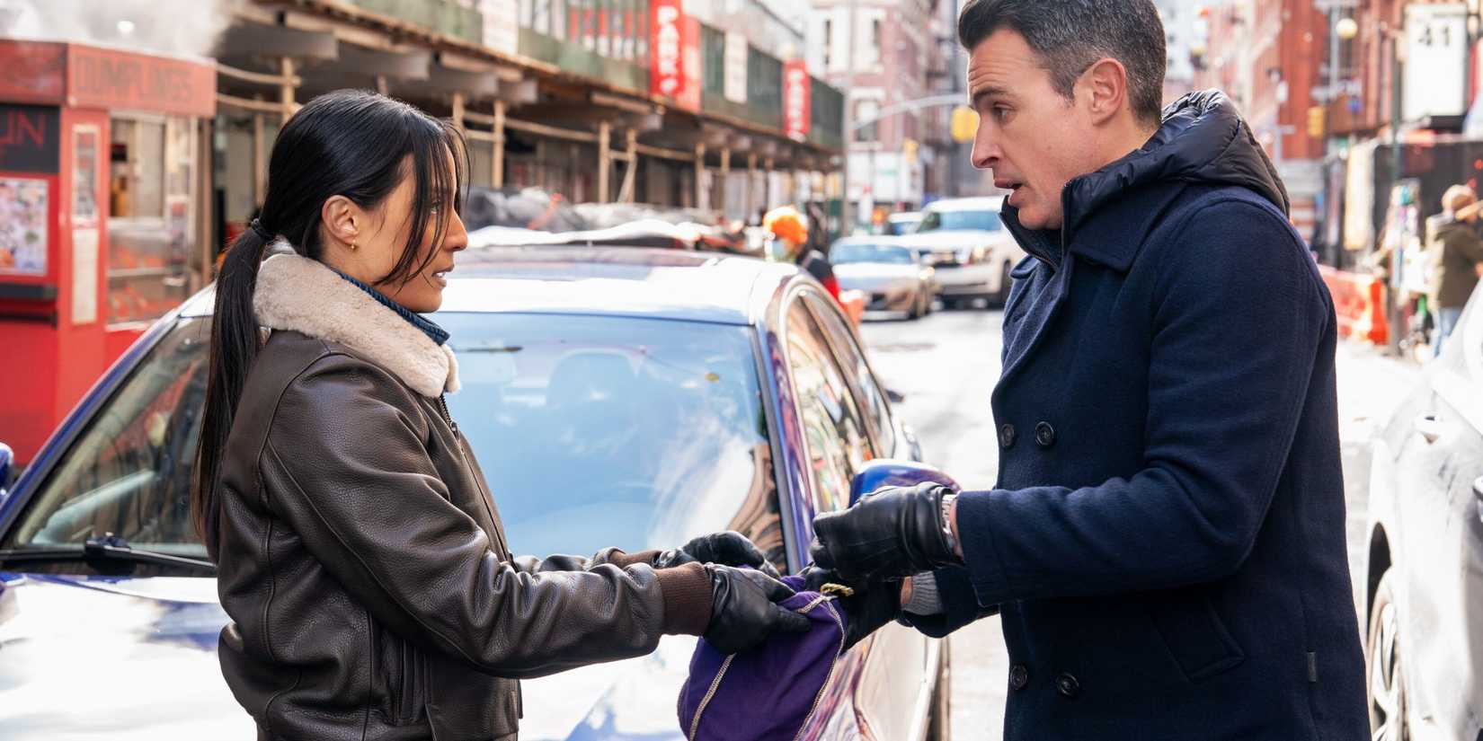 FBI Dani holding a bag that Scola is putting something into