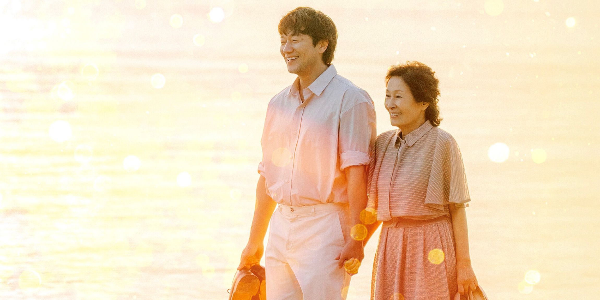A seemingly young man and much older woman walking while smiling and holding hands in the K-drama Heavenly Ever After