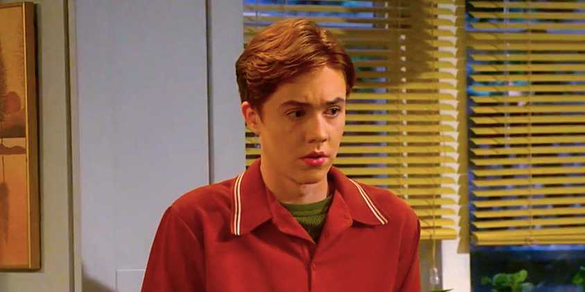 Ames McNamara's Mark looks suspicious standing in the kitchen from The Conners season 7 episode 3