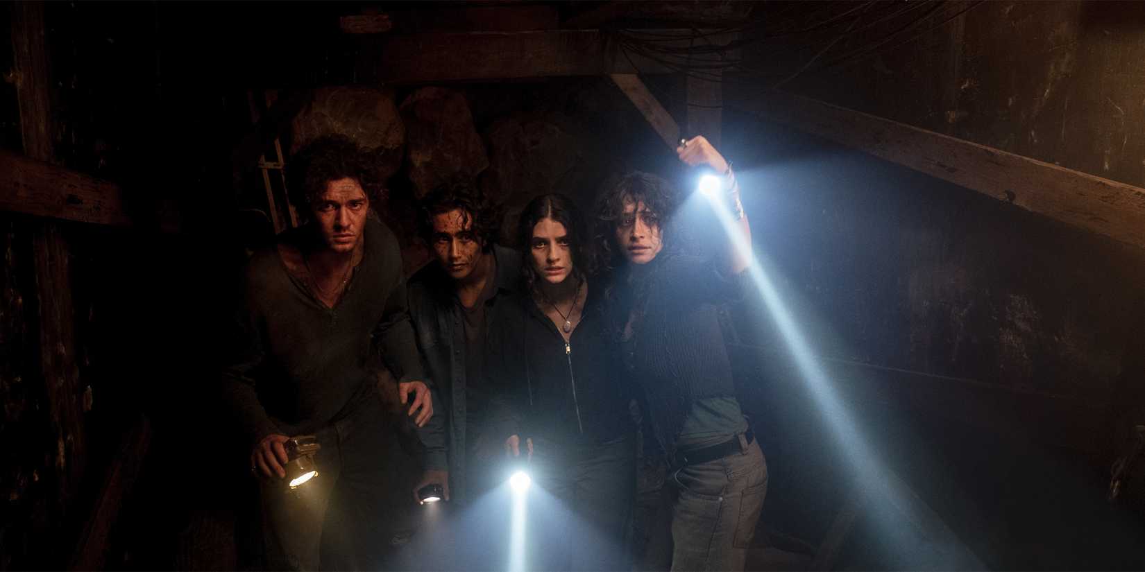 Belmont Cameli & Until Dawn cast with flashlights in the dark, as all look afraid