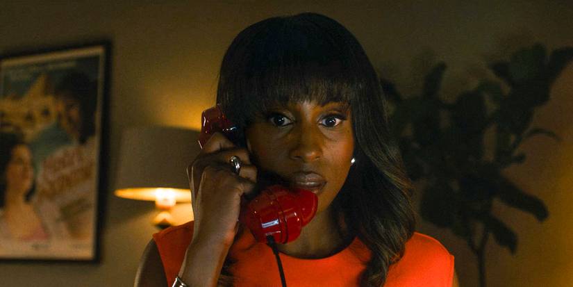 Brandy (Issa Rae) talking on a red rotary phone in Black Mirror season 7, episode 3, "Hotel Reverie"
