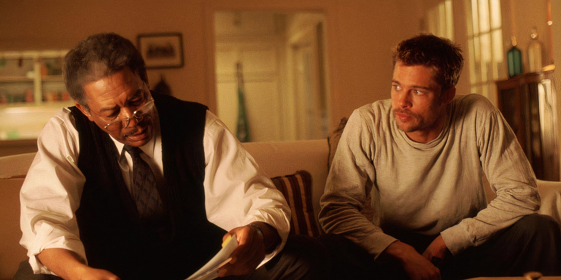 Morgan Freeman and Brad Pitt sit next to one another on a couch. 