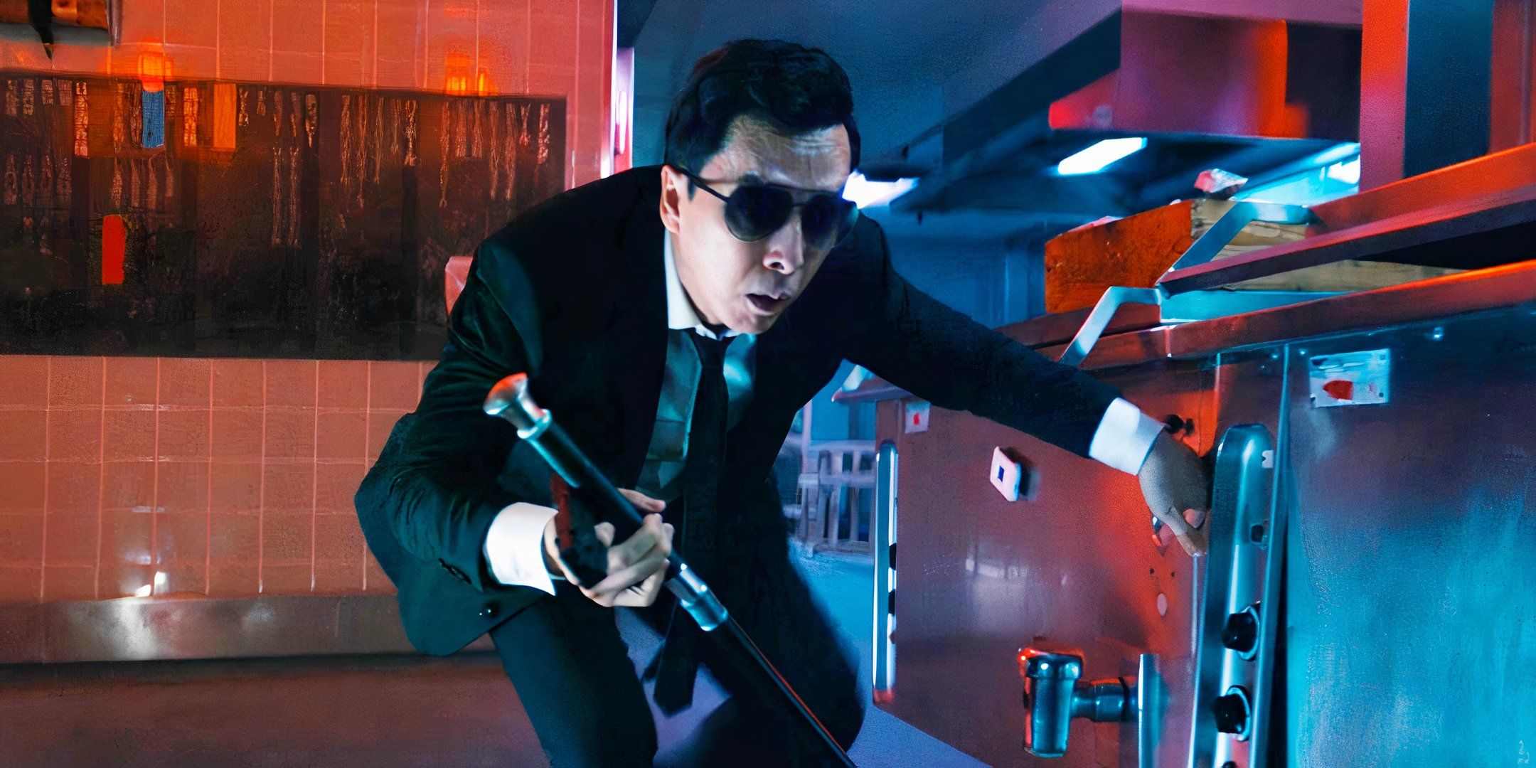 Donnie Yen as Caine crouching down behind a countertop in John Wick: Chapter 4