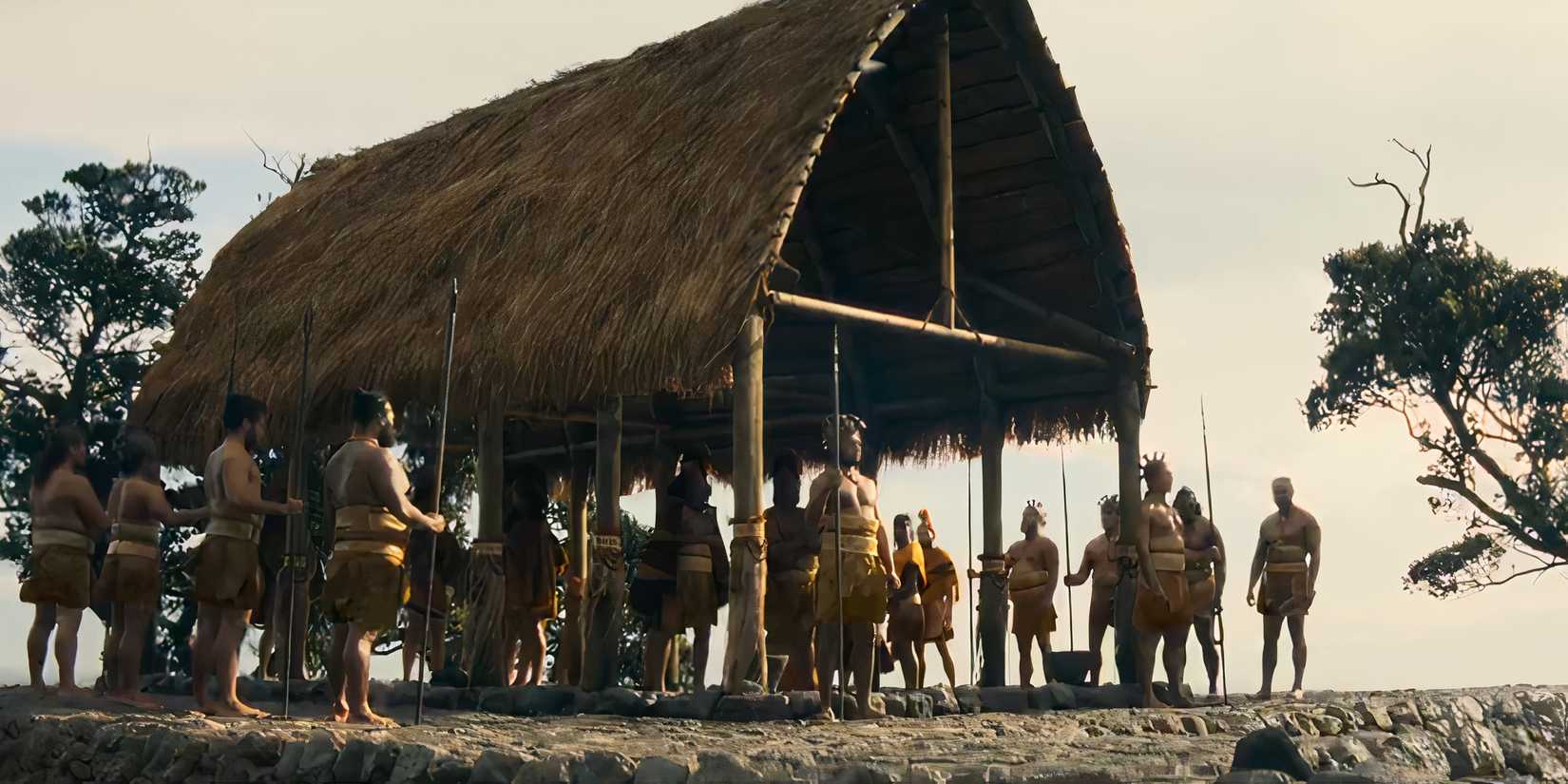 A tribe with spears stands beneath a wooden structure in Chief of War