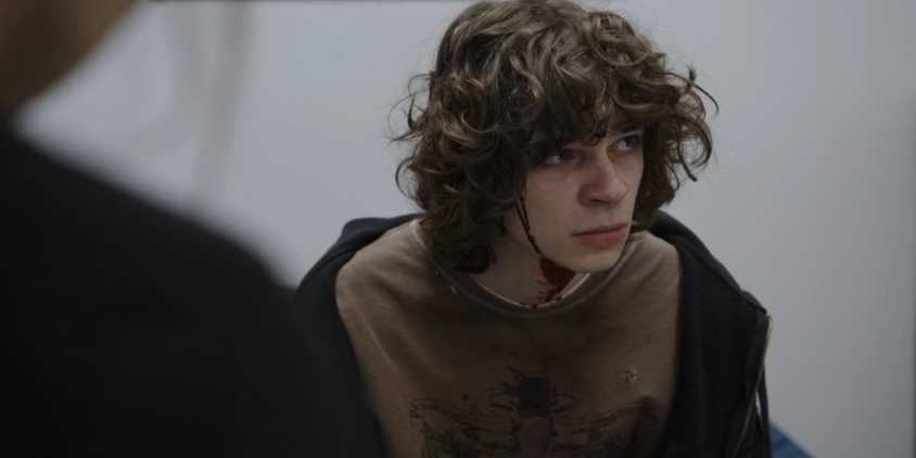 David Saunders (Jackson Kelly) with blood trickling from his head in a hospital room in The Pitt season 1, episode 14