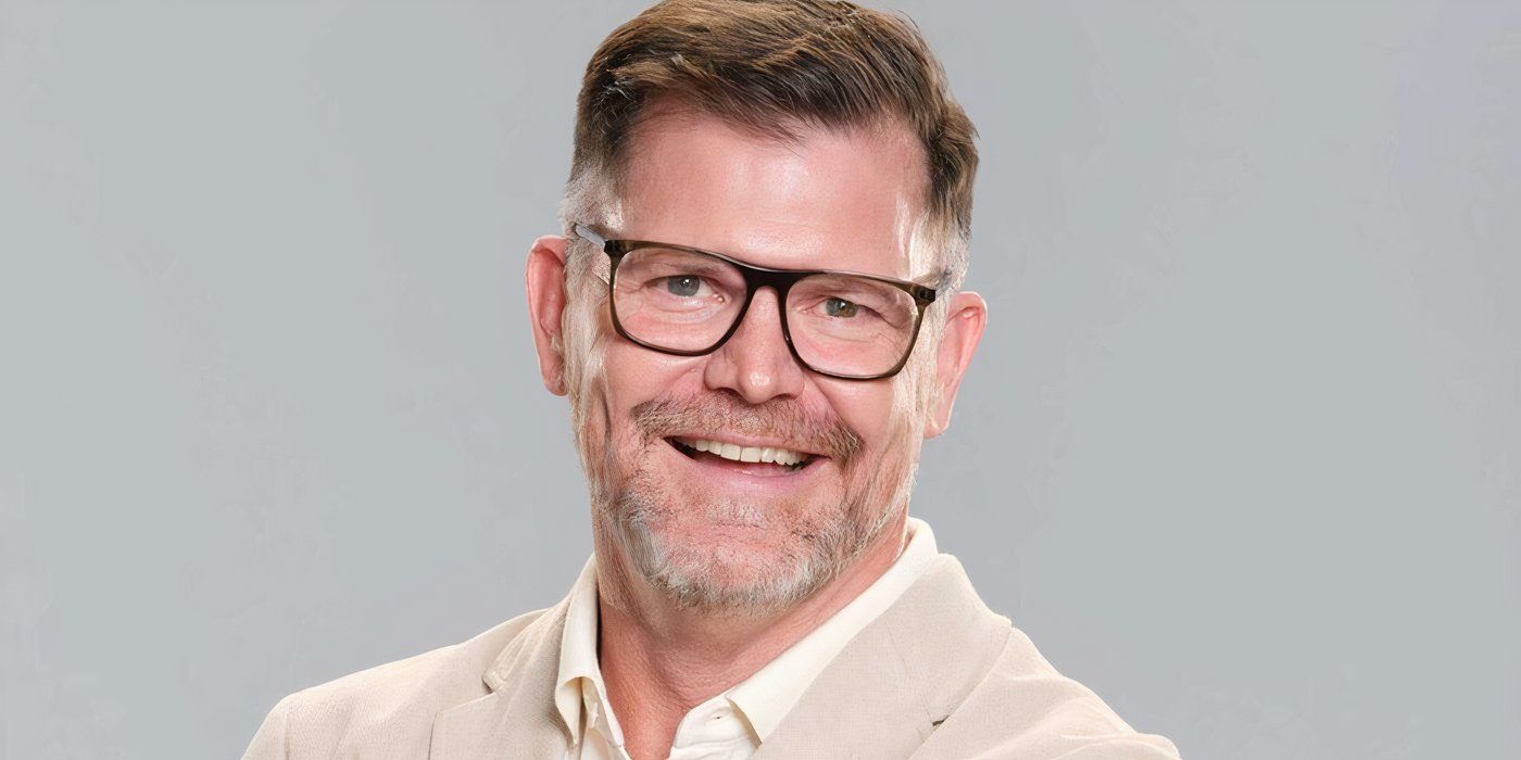 Destination X Season 1's Rick Szabo smiling against a gray background.