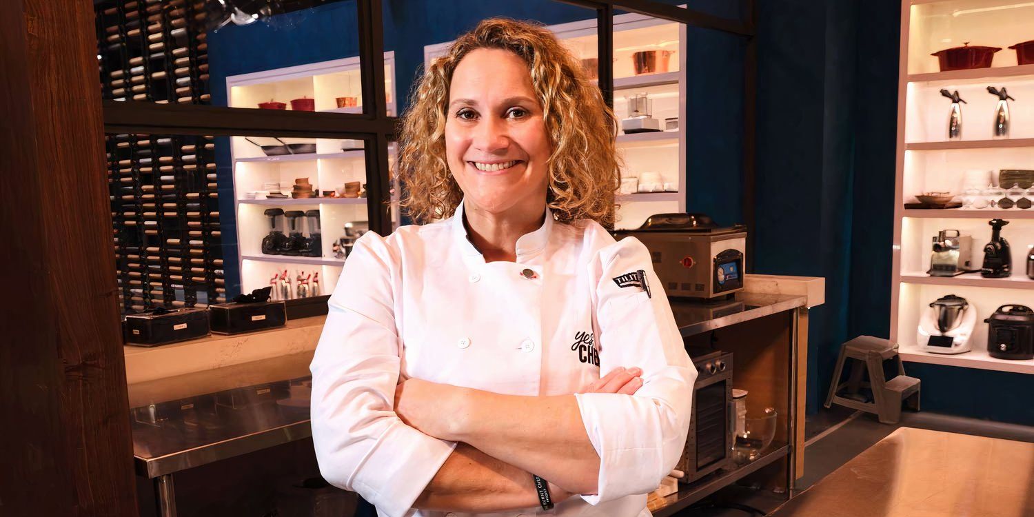 Emily posing, smiling with arms crossed in a kitchen
