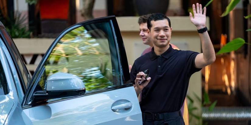 Gaitok (Tayme Thapthimthong) waving from a car in The White Lotus season 3, episode 8.