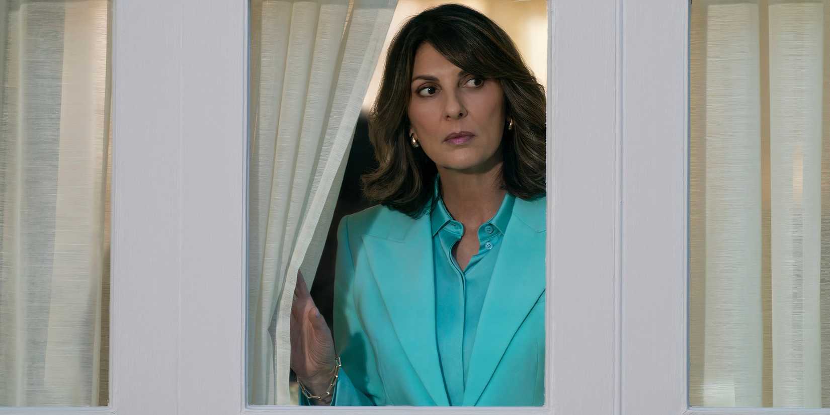 Gina Bellman as Sophie looking suspiciously out of a window in Leverage: Redemption Season 3