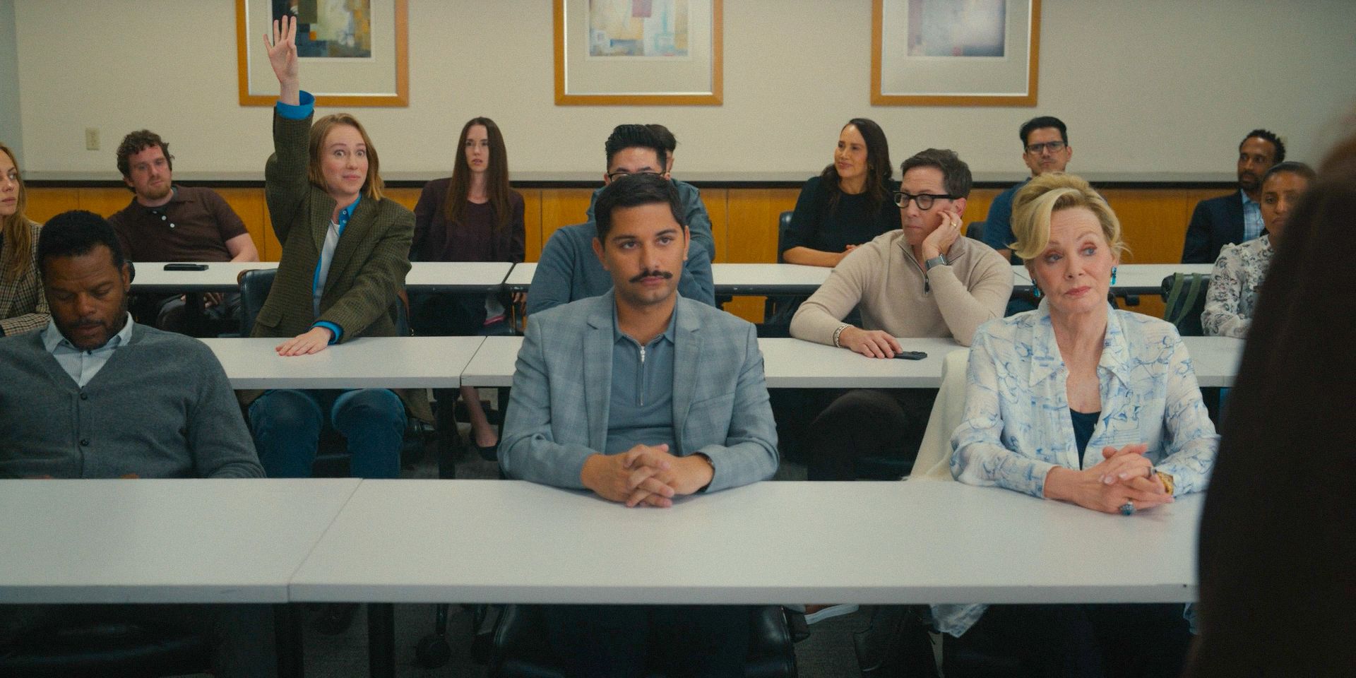 Ava Daniels (Hannah Einbinder) raising her hand in a meeting in Hacks - S4; Ep 1
