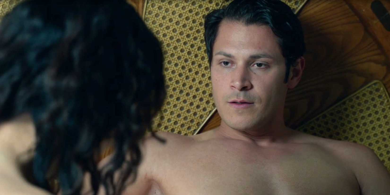 Ivan Munos (Alex Meraz) sitting shirtless in bed with Bernadette Manuelito in Dark Winds season 3, episode 5