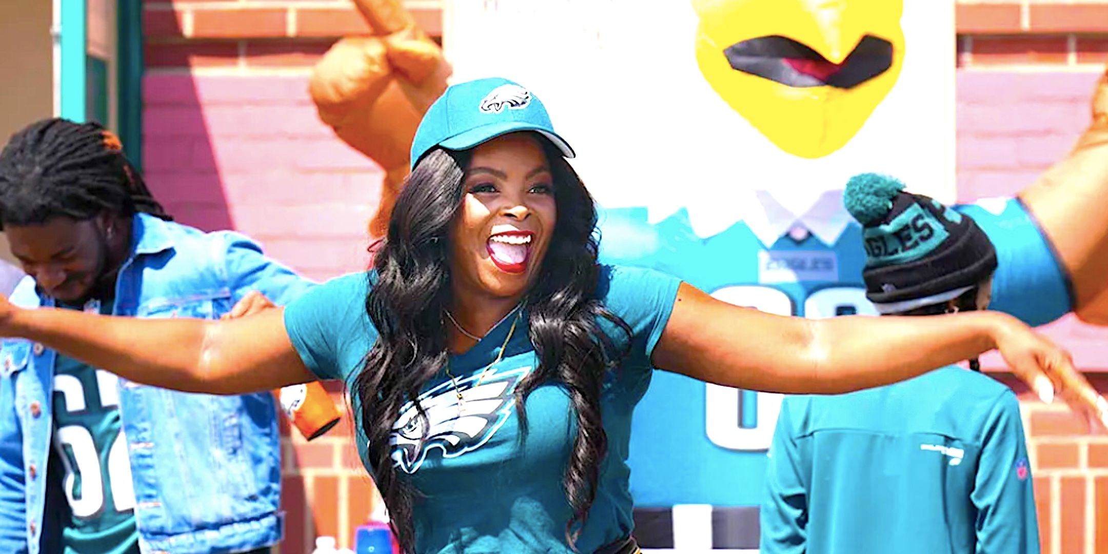 Janelle James' Ava looking excited in an Eagles jersey outside the school from Abbott Elementary