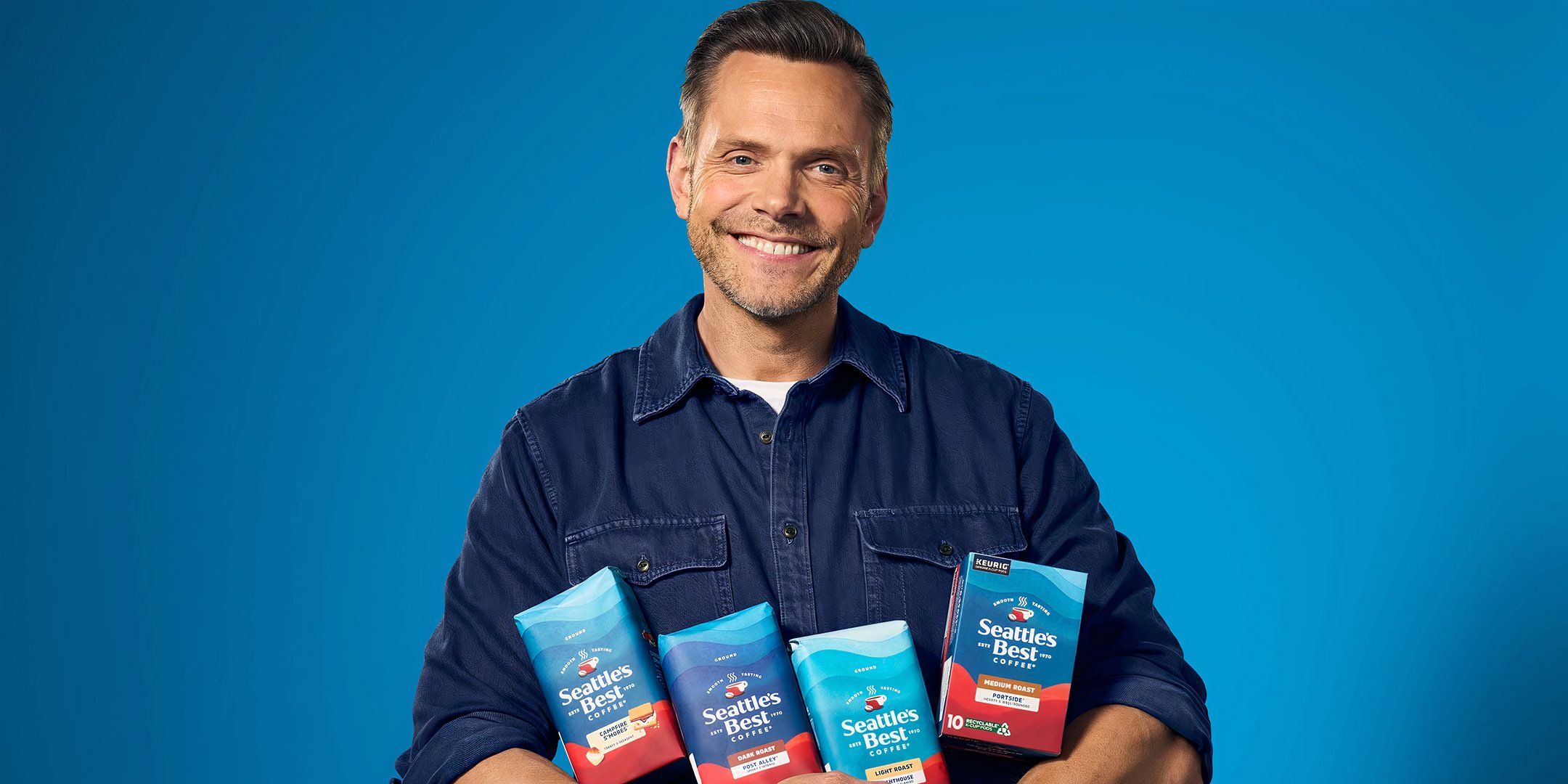 Joel McHale holding a selection of Seattle&rsquo;s Best Coffee bags