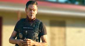 Kevin Bacon looks down angrily in a scene from The Bondsman