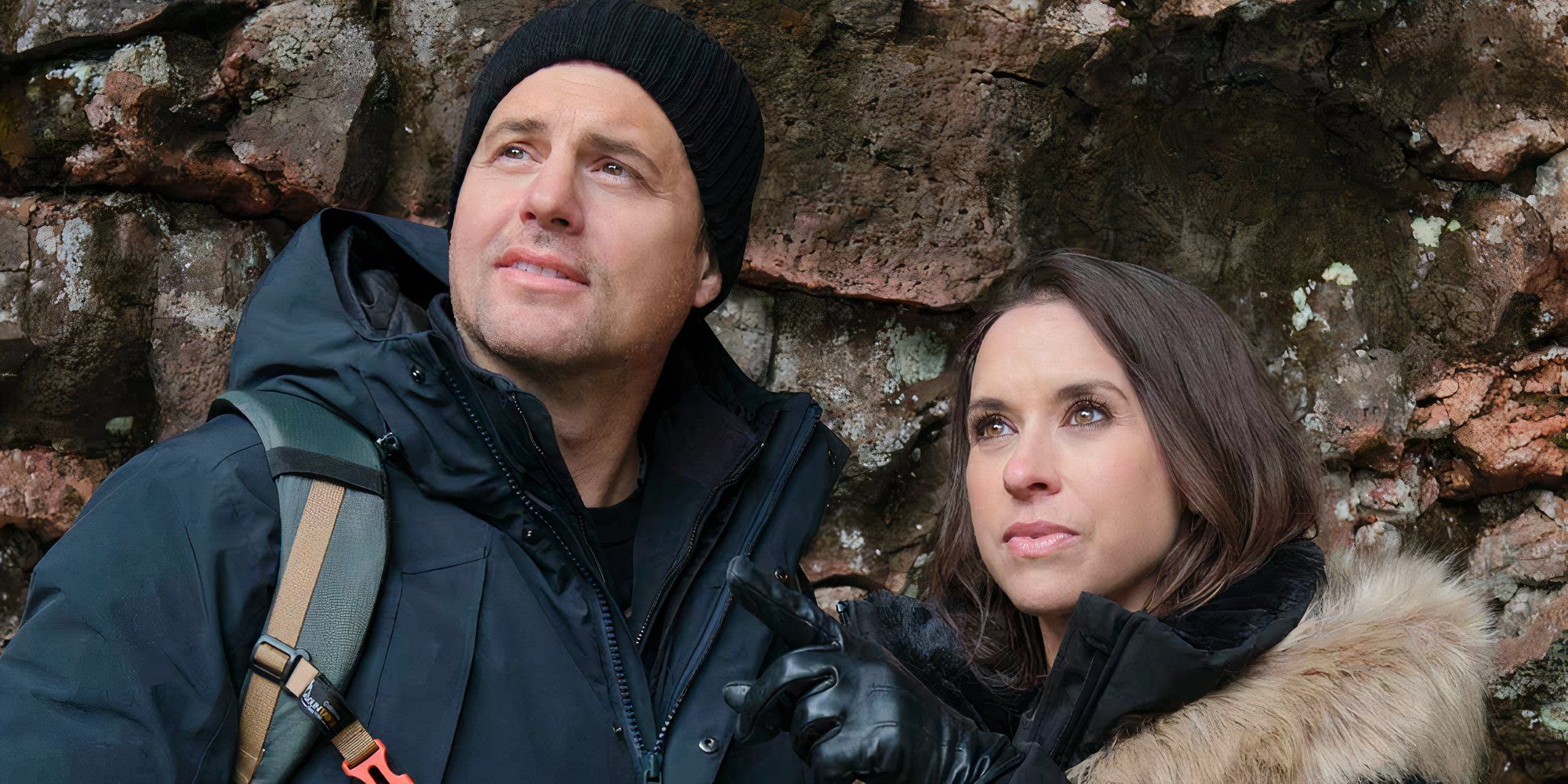Kristoffer Polaha and Lacey Chabert in winter gear looking at something off screen in The Christmas Quest