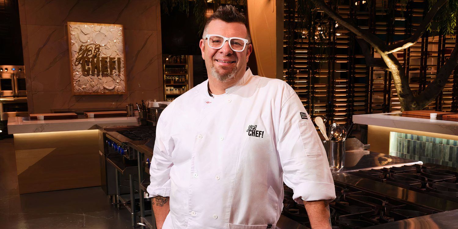 Lee posing and smiling with a kitchen behind him